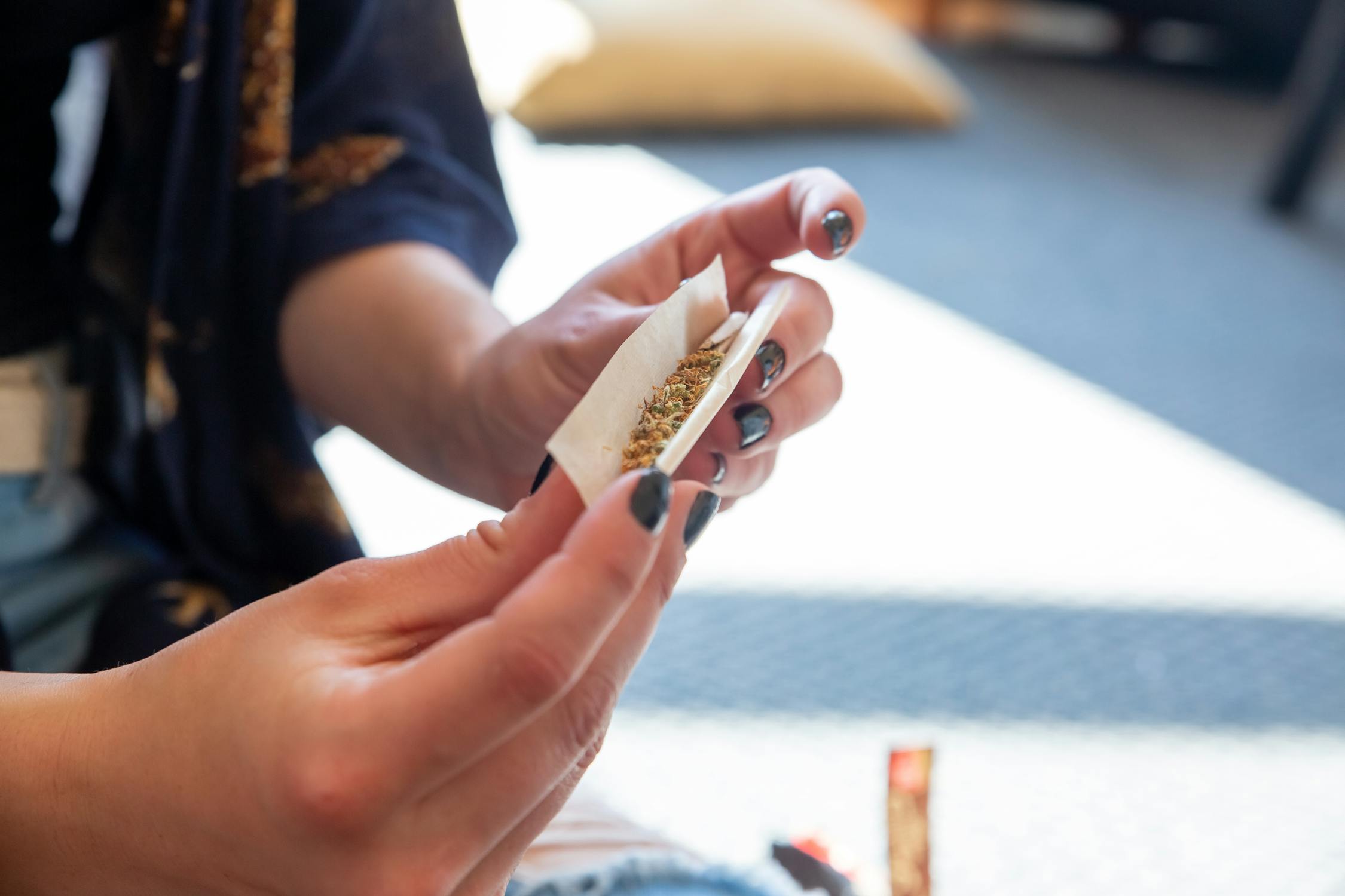 Person rolling a cannabis pre-roll joint